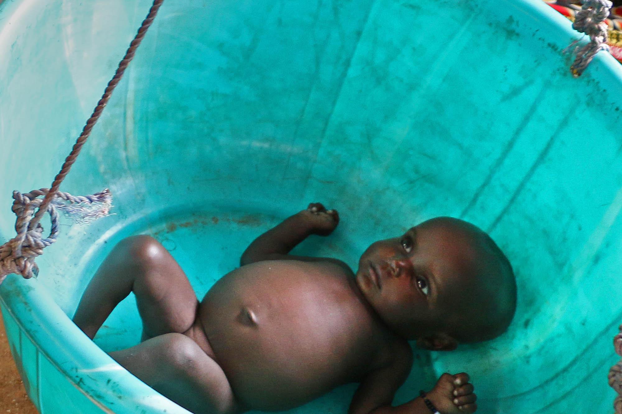 A baby is being weighed in a village in Chad.